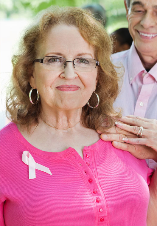 A couple with a child standing in front of their home