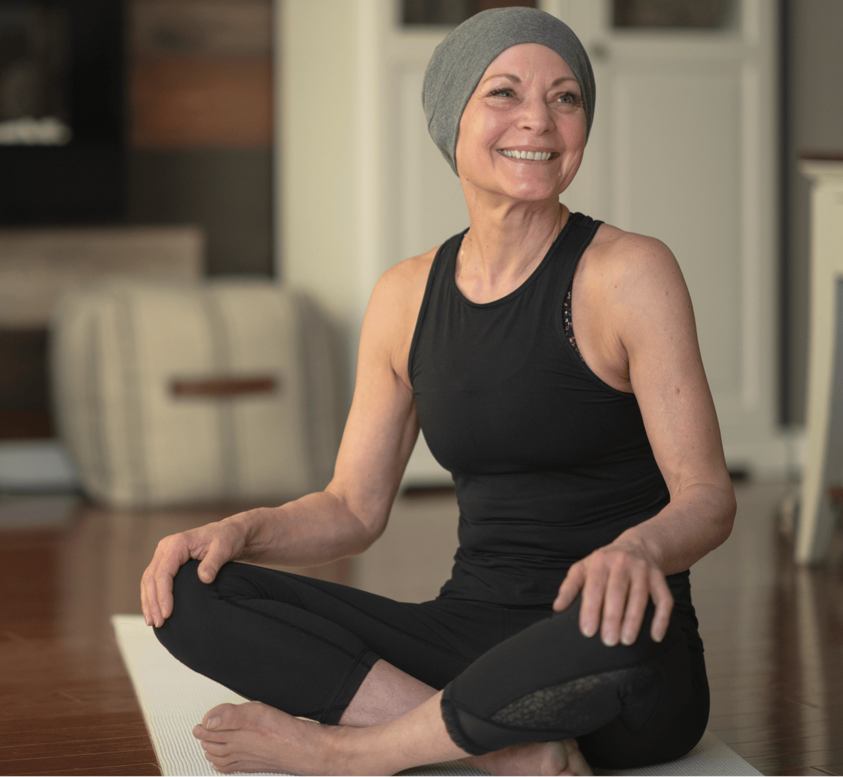 Woman sitting on a yoga mat with a head covering