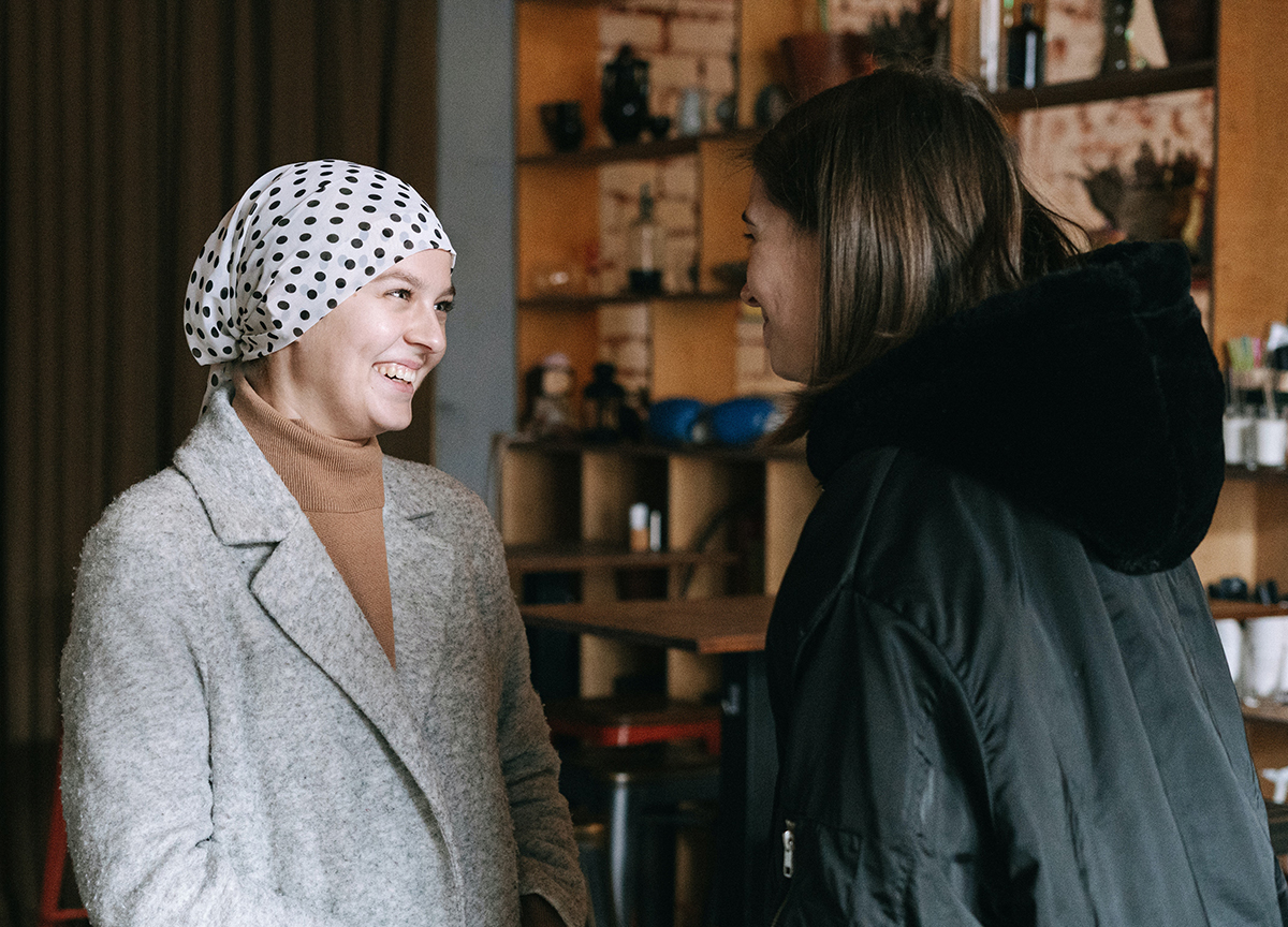 Woman with head covering talking to a friend